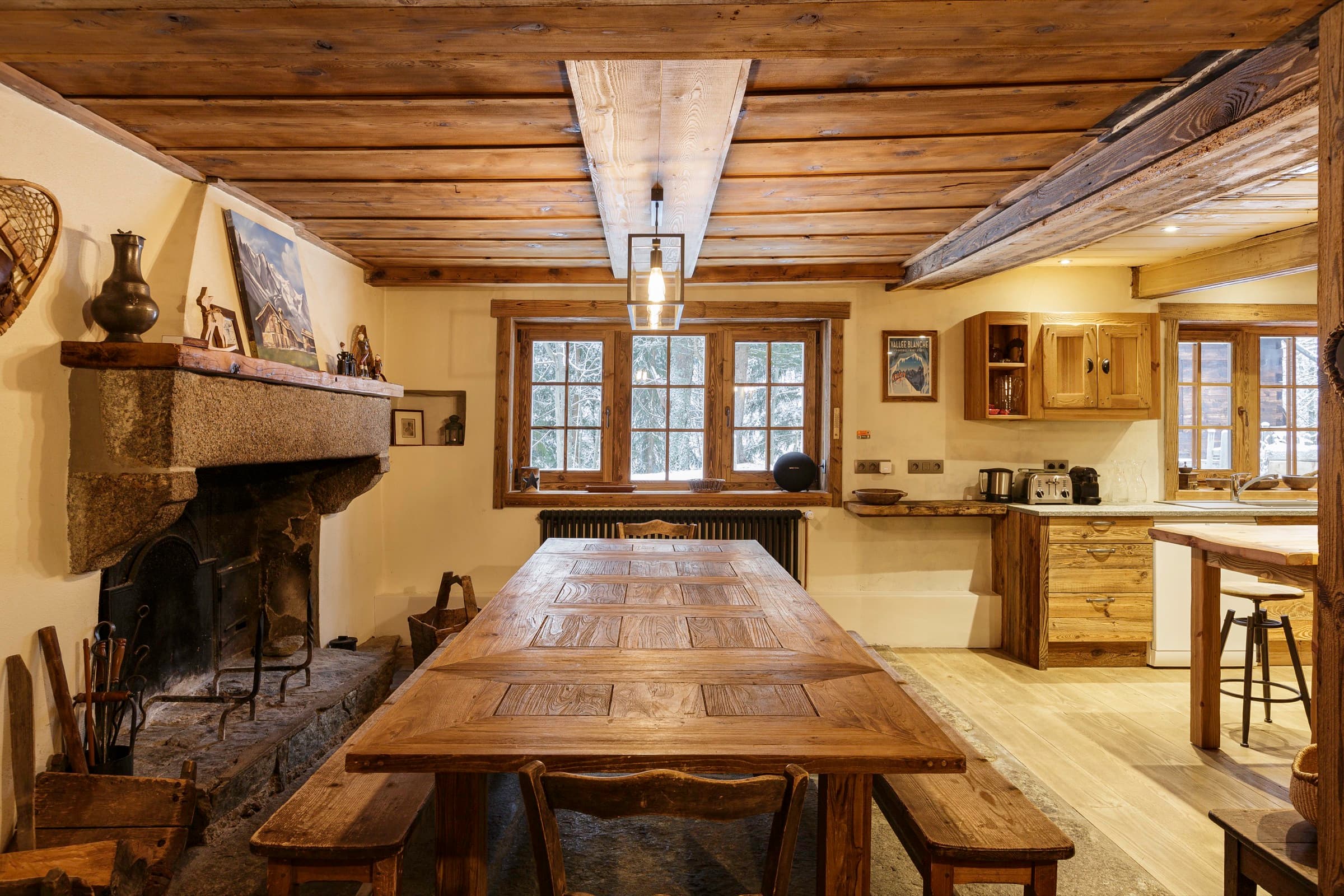 Salle à manger du chalet Le Solerey, longue table et cheminée en granit